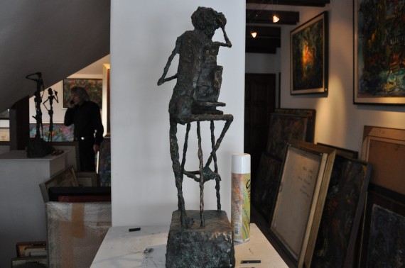 Sculpture on plinth in Ernő Tóth's studio with stacked paintings